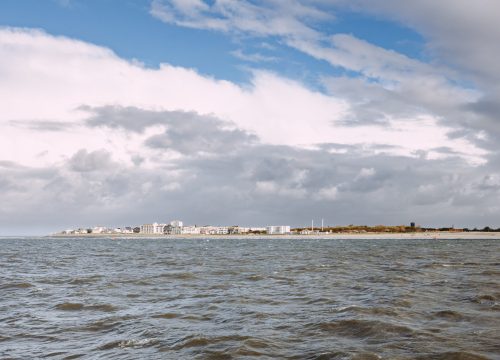 Blick vom Meer auf die Insel Norderney mit Ortschaft und Strand