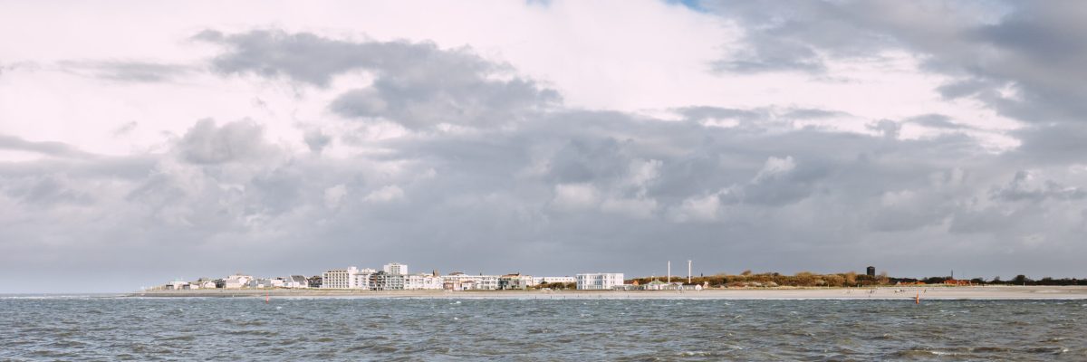 Blick vom Meer auf die Insel Norderney mit Ortschaft und Strand